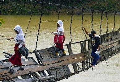  این دانش آموزان اندونزیایی در منطقه « لیبک» قرار دارند و باید برای مدرسه رفتن از روی این پل معلق و آسیب دیده رد شوند