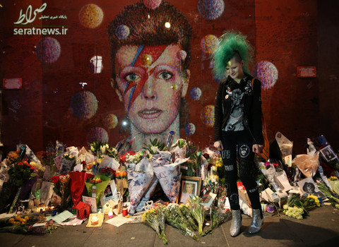 هوادار دیوید بویی  موسیقی‌دان و خواننده در اولین سالمرگ او مقابل یک نقاشی دیواری در جنوب لندن
