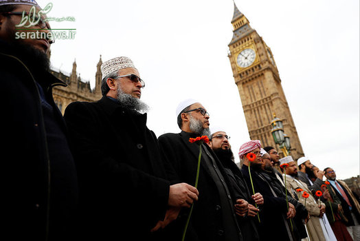 مردان مسلمان با شاخه گلی در دست بر روی پل وست مینستر به منظور ادای احترام به قربانیان حمله تروریستی مقابل پارلمان انگلیس