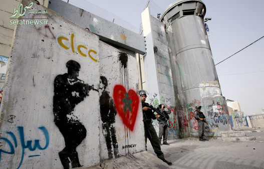 نیروهای نظامی رژیم صهیونیستی در مقابل دیوار نقاشی شده حائل