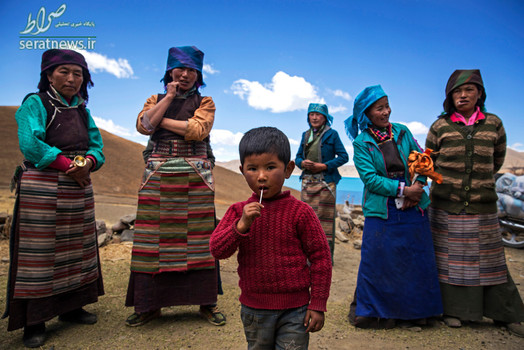 آب نبات خوردن یک کودک در کنار چند زن روستایی تبتی 