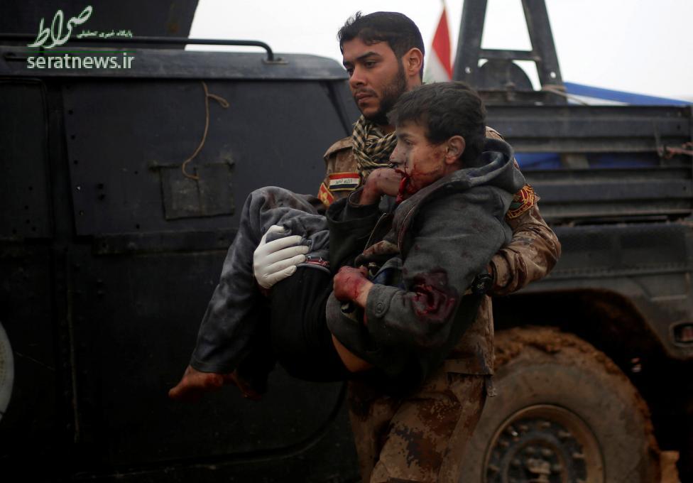 عکس/سرباز آمریکایی در حال حمل پسربچه مجروح