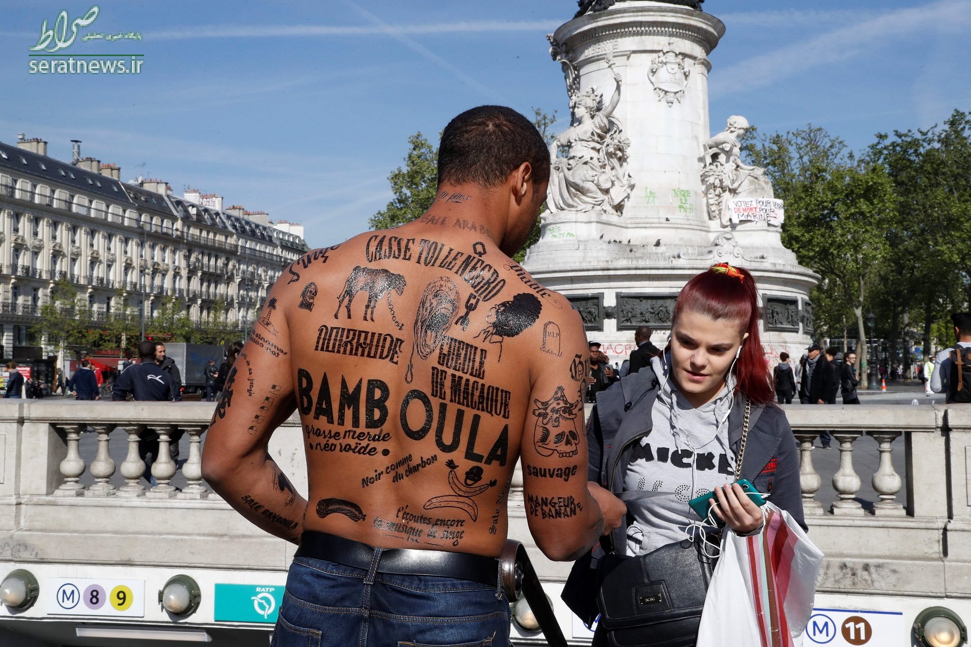 مردی در پاریس فرانسه که در اعتراض به نژادپرستی توهین های نژادپرستانه بر روی بدن خود نوشته است