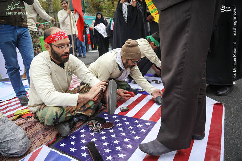 عکس/ واکس زدن کفش راهپیمایان بر روی پرچم آمریکا