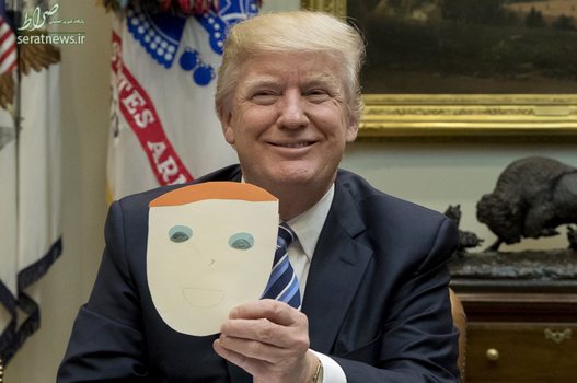 دونالد ترامپ رییس جمهور آمریکا در حال نشان دادن یک نقاشی از چهره خود که توسط یک کودک ترسیم شده