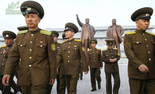 سربازان کره شمالی در مقابل مجسمه های برنزی از کیم ایل سونگ و کیم جونگ ایل رهبران سابق این کشور در پیونگ یانگ
